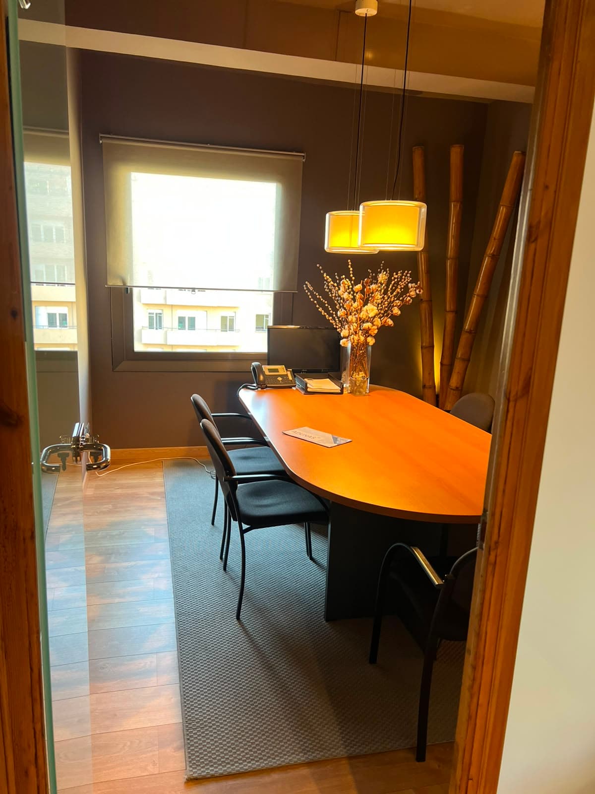 Sala de reuniones de ADUNAS — mesa de juntas con luz natural y carácter cálido.